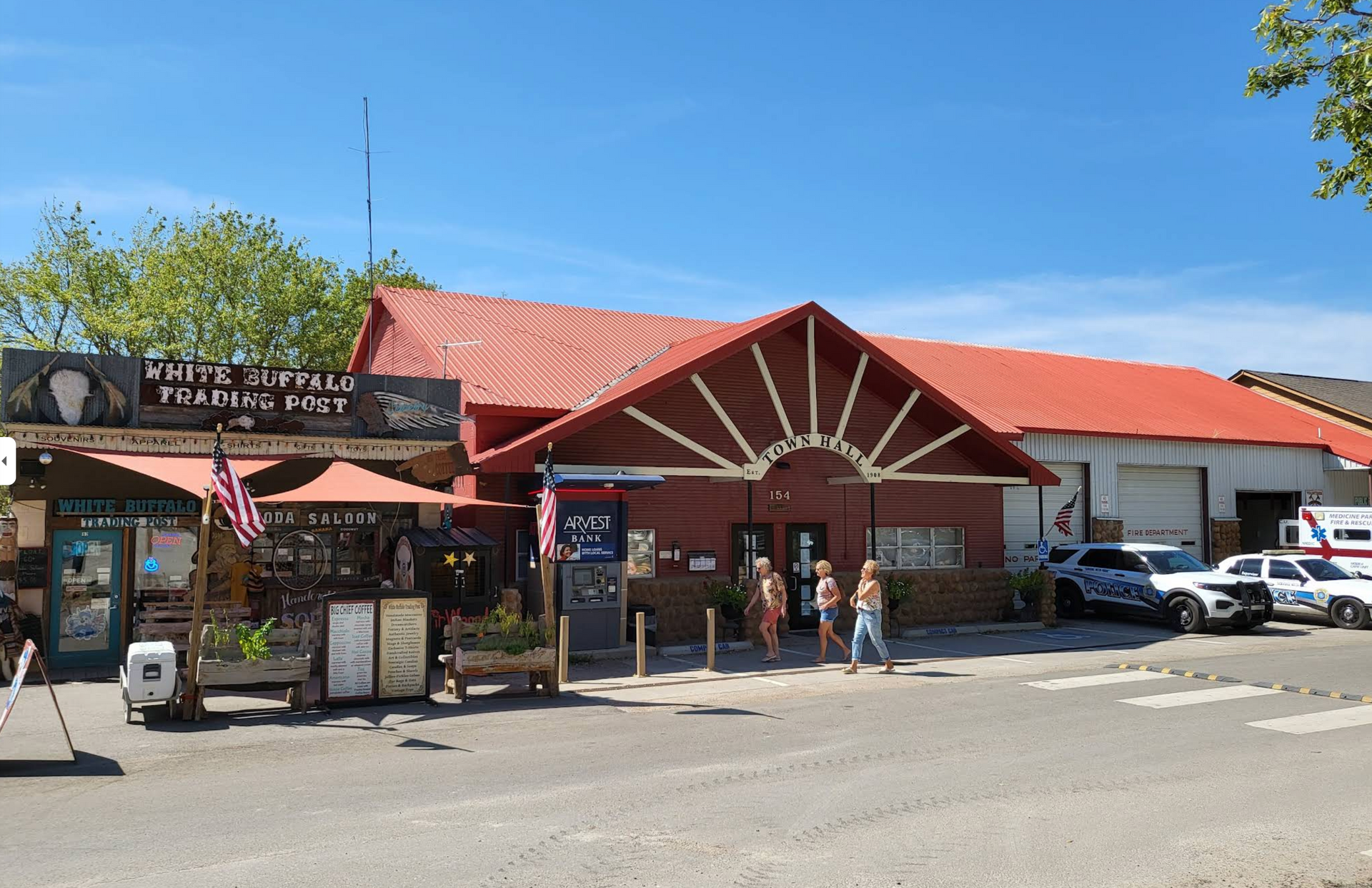 Small roadside shop with red roof and outdoor seating on a sunny day