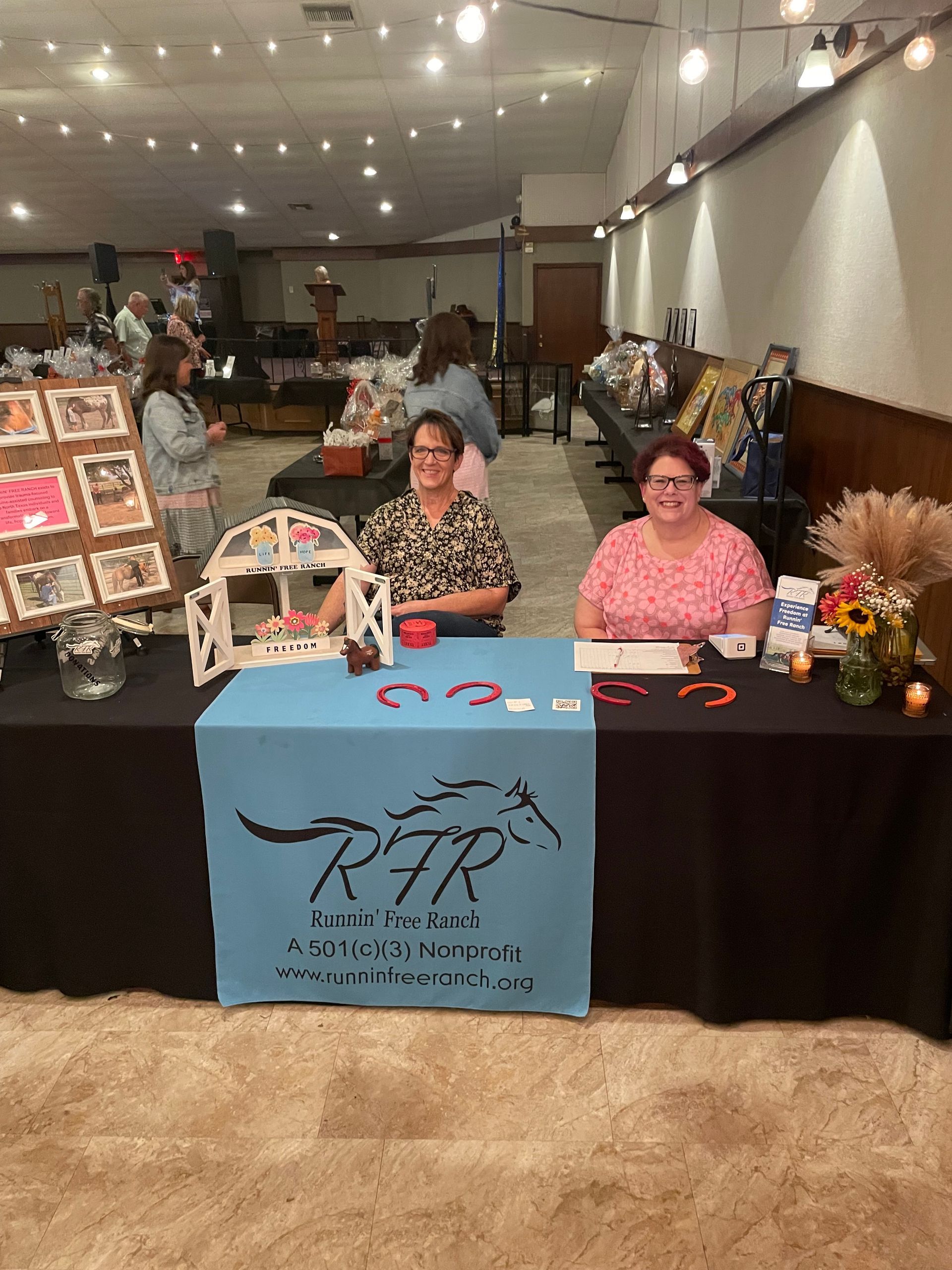 Group of kids pose with a pony, decorated with colorful handprints, on a farm.