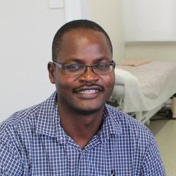 doctor smiling in front of hospital bed