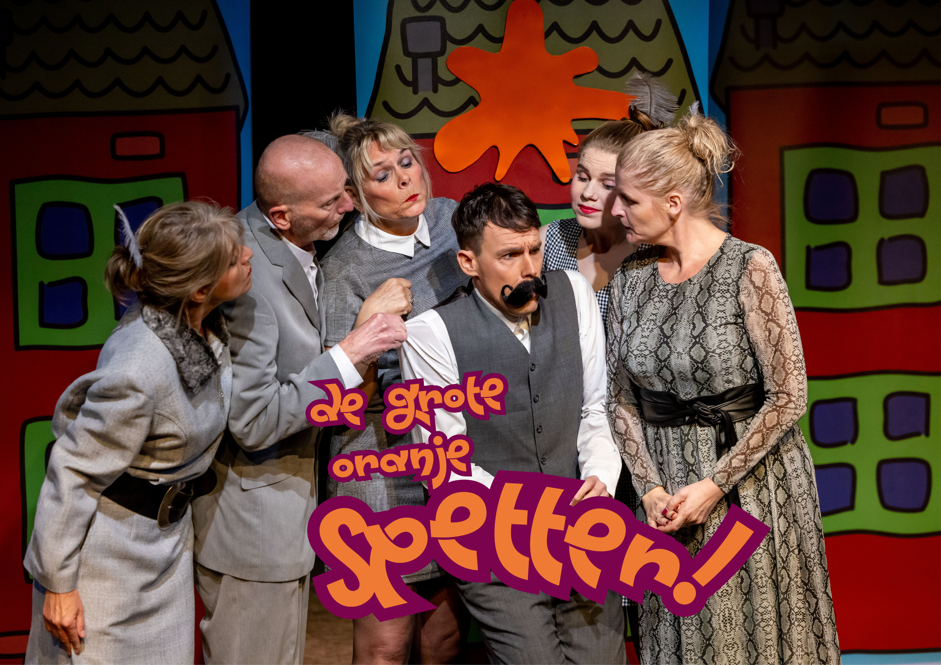 Een groep acteurs in een kleurrijk decor, sommigen houden een man met een grote snor vast; de tekst luidt: 