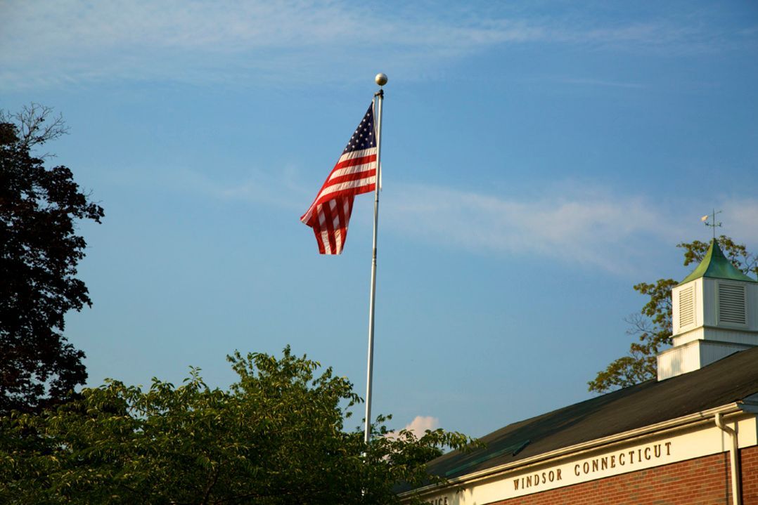 An american flag is flying in front of a building.
