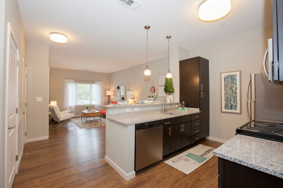 A kitchen with granite counter tops and stainless steel appliances in a house.