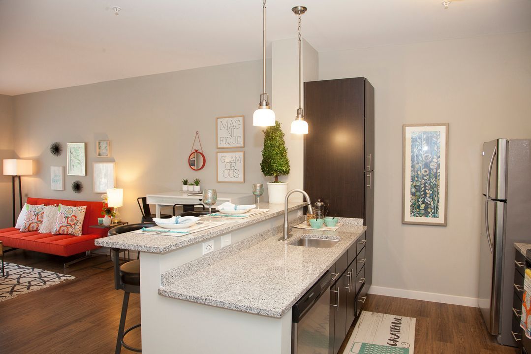 A kitchen with granite counter tops and a stainless steel refrigerator.