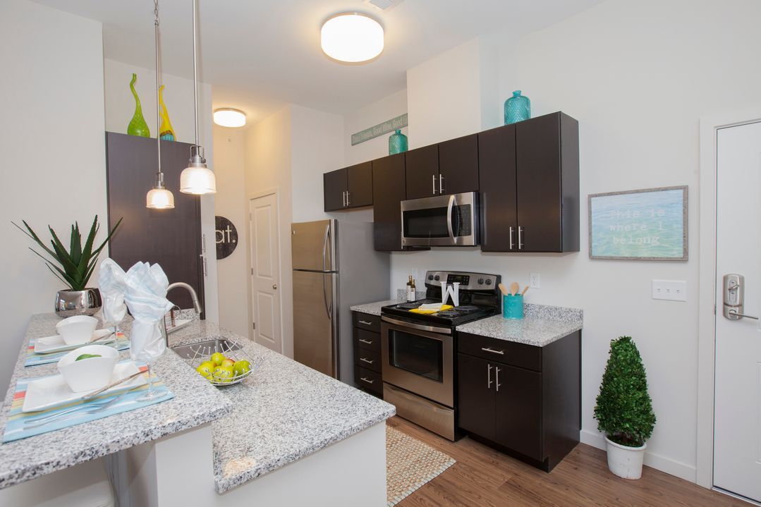 A kitchen with stainless steel appliances and granite counter tops.