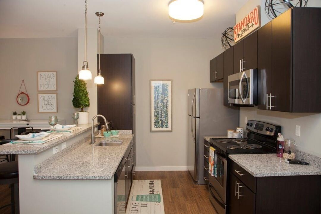 A kitchen with stainless steel appliances and granite counter tops.