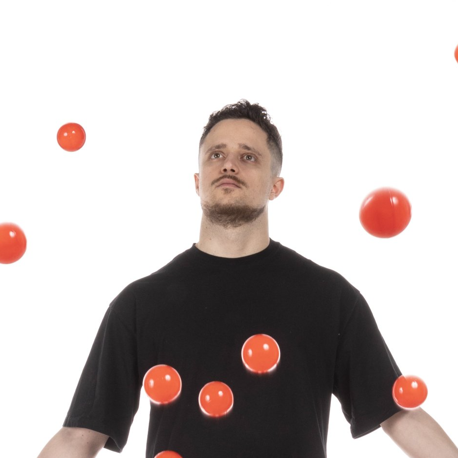 un uomo in una maglietta nera sta giocando con le palle rosse