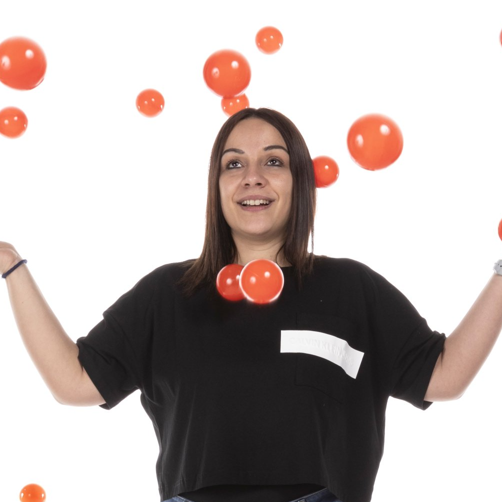 una donna che indossa una maglietta nera è circondata da palloncini arancioni