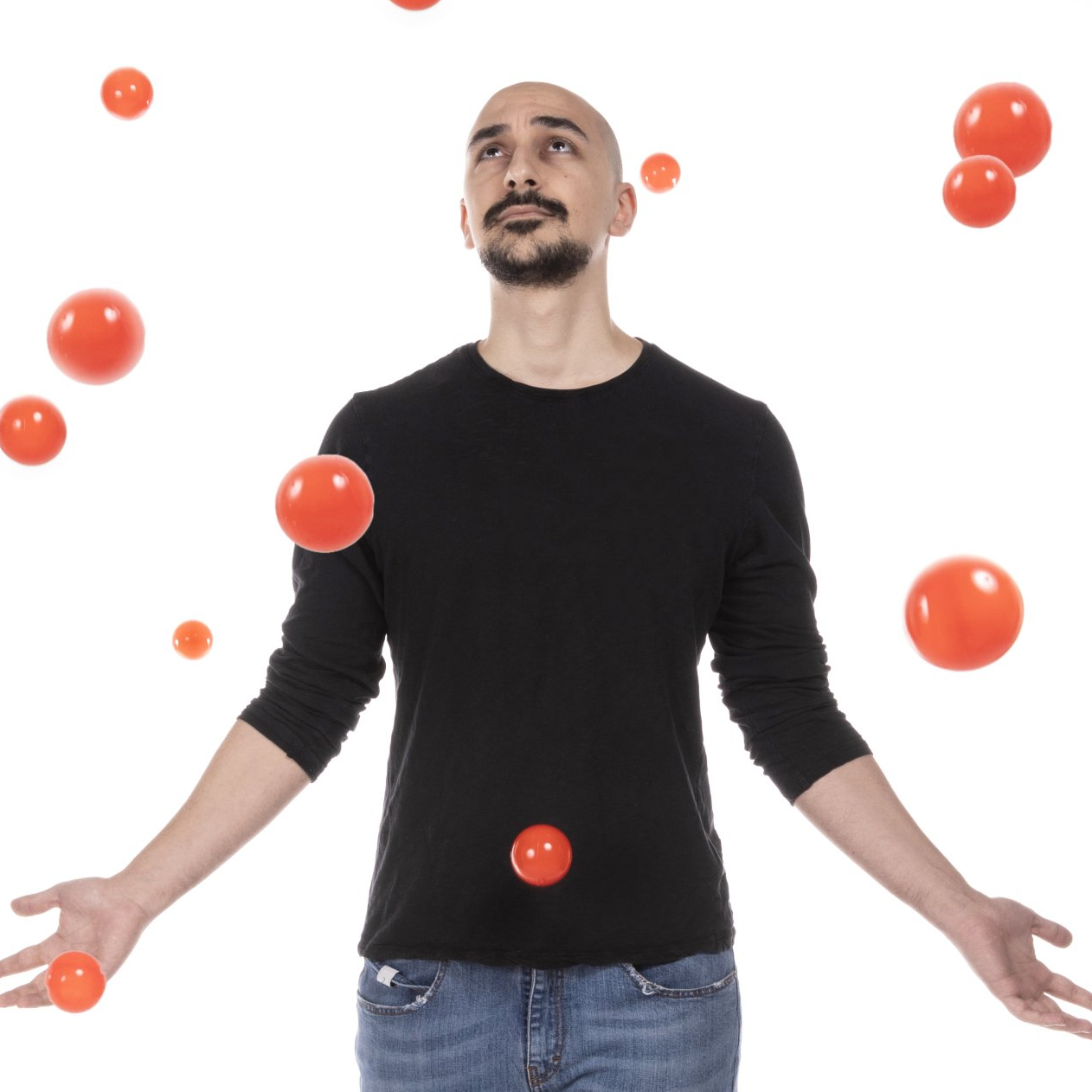 un uomo in una maglietta nera sta giocando con le palle rosse