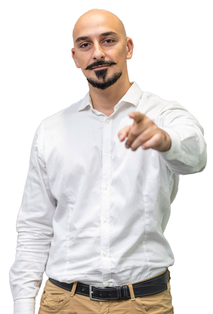 Un uomo calvo con barba e baffi sta indicando la telecamera.