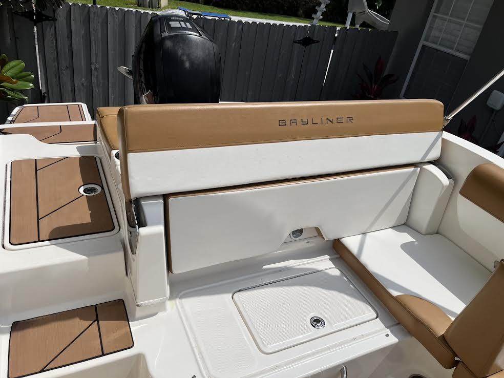 Boat interior with tan and white seating, storage, and a 
