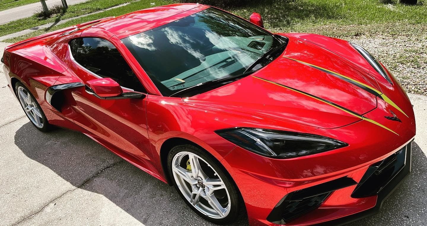 Red Chevrolet Corvette sports car parked on a driveway.