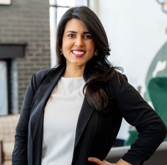 A man and a woman are sitting on a dock overlooking a lake.