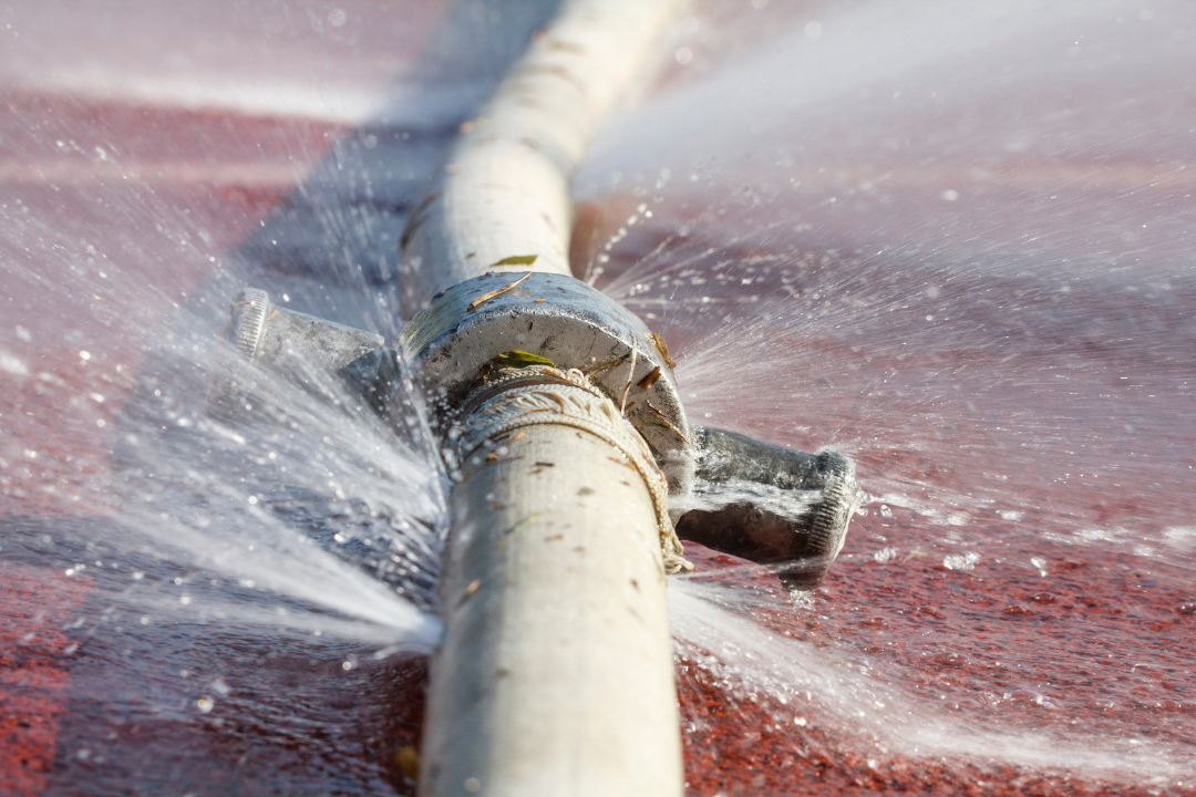 A water pipe is leaking water on the ground.