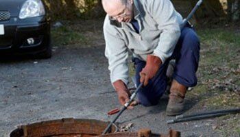 Man Cleaning The Manhole — Plumbing Repairs in Saint Ann, MO