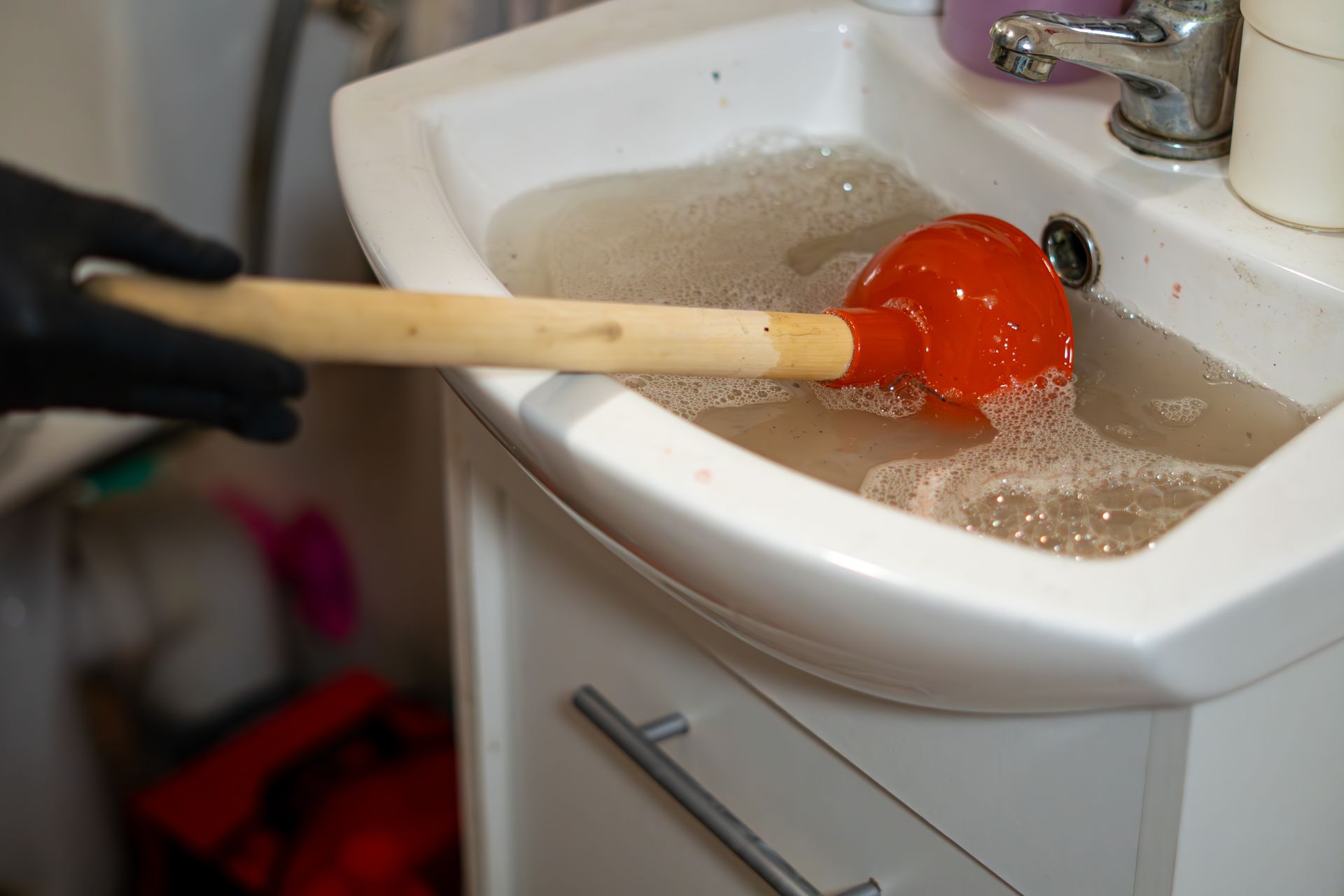 A clogged bathroom sink is unclogged with a rubber plunger