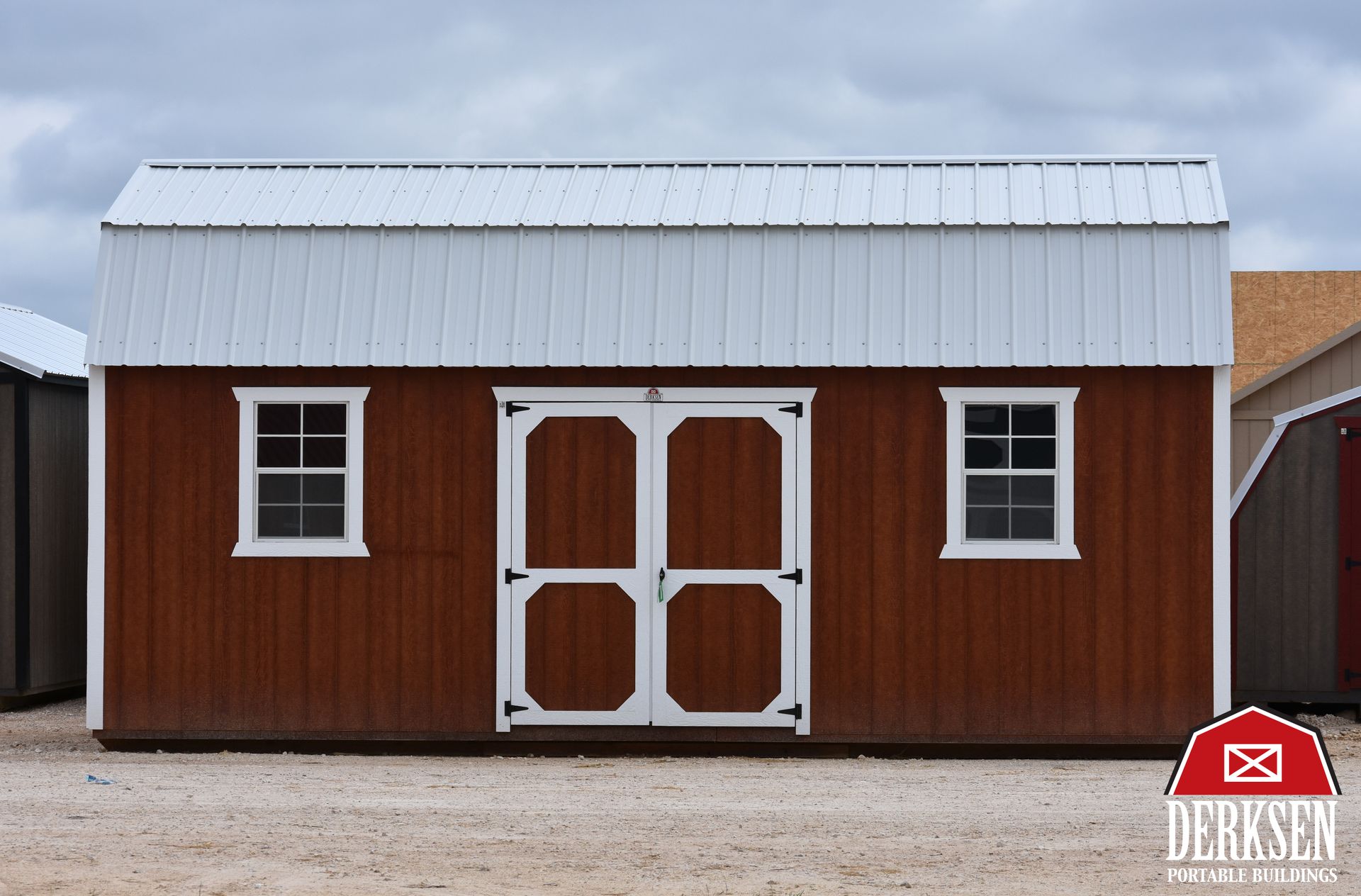 A small red shed with a white door and window