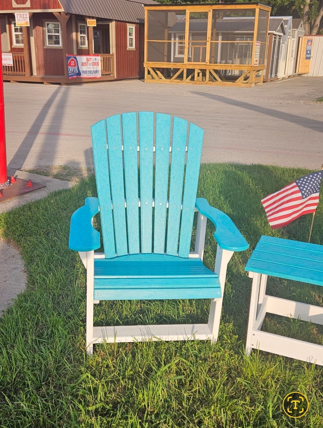 A row of colorful adirondack chairs are lined up on gravel