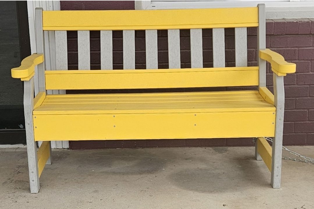 A row of colorful adirondack chairs in a grassy field