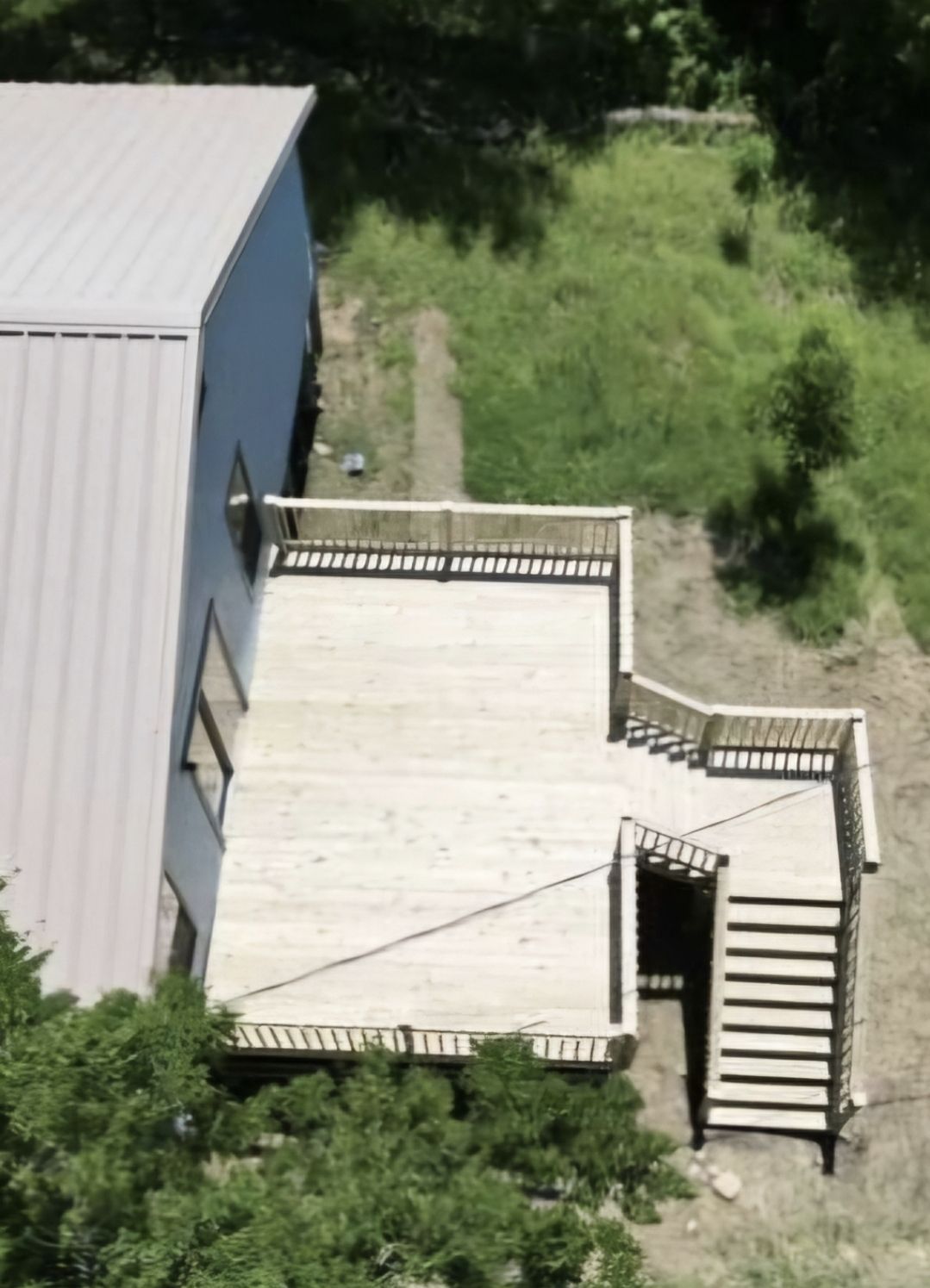 A wooden deck surrounded by trees on a sunny day