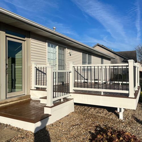 A house with a deck and stairs in front of it.