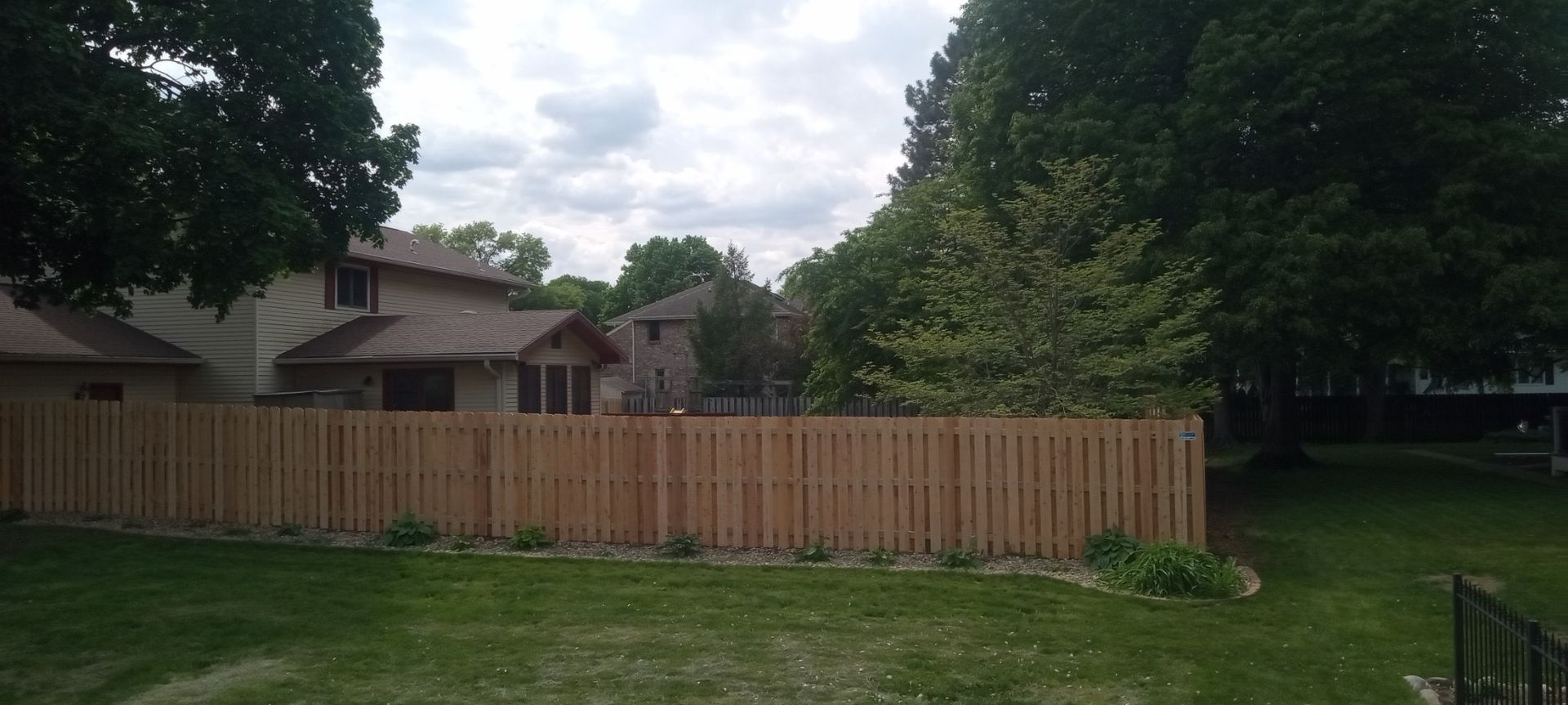 There is a wooden fence in the backyard of a house.