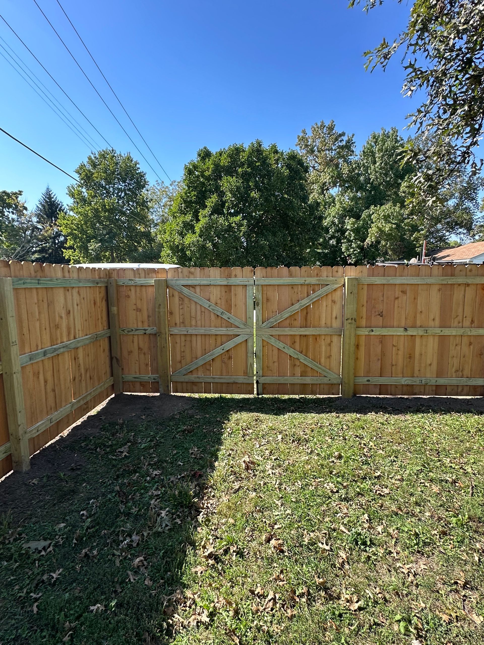 A wooden fence with a gate in the backyard.