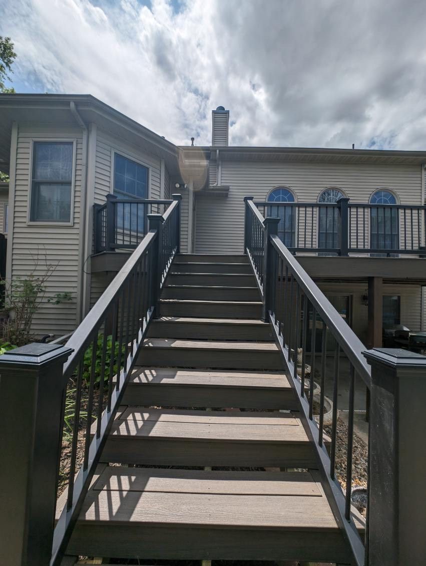 A set of stairs leading up to a house with a balcony.