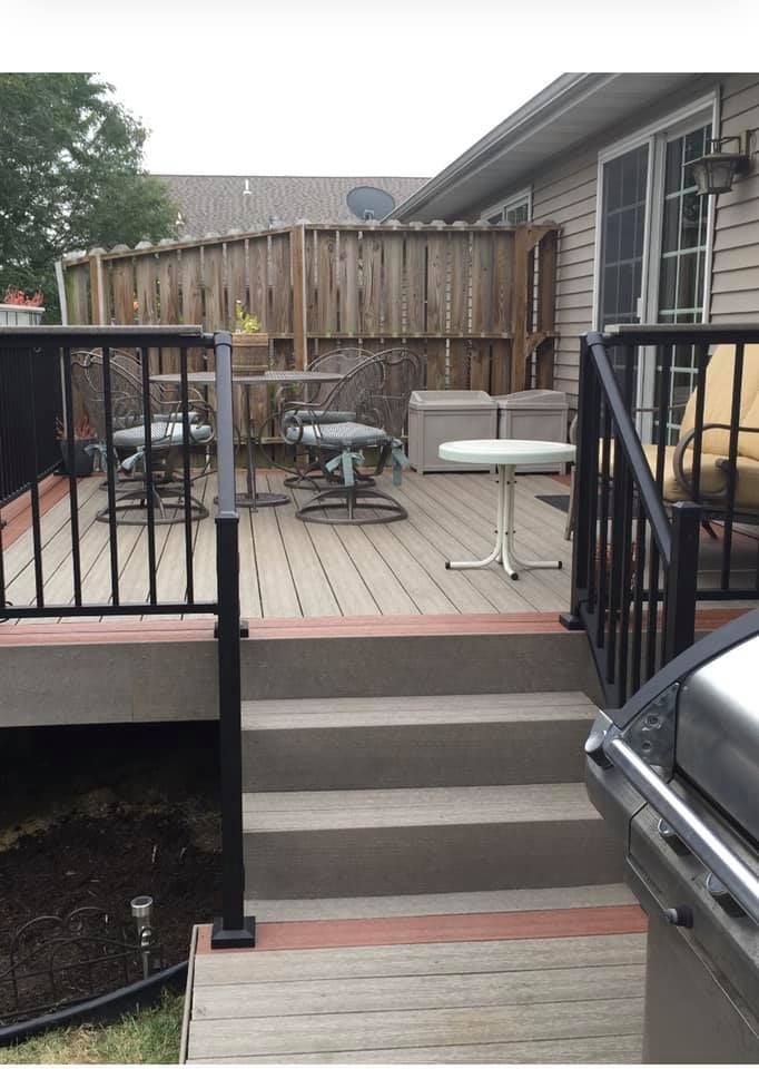 A deck with stairs leading up to it and a grill.