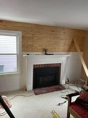 A living room with a fireplace and a window.