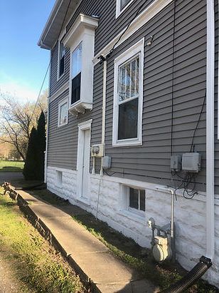 The side of a house with a walkway leading to it.