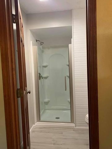 A bathroom with a walk in shower and a toilet.
