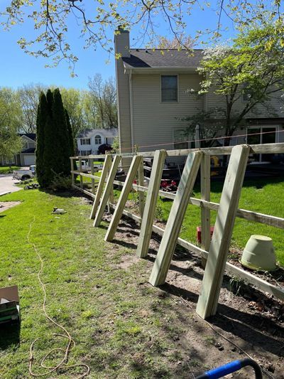 A wooden fence is being built in front of a house.