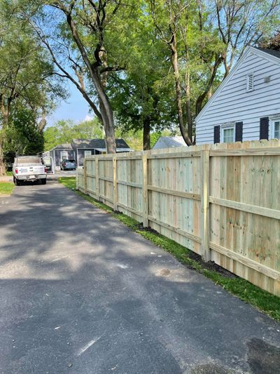 A wooden fence is being built in front of a house.