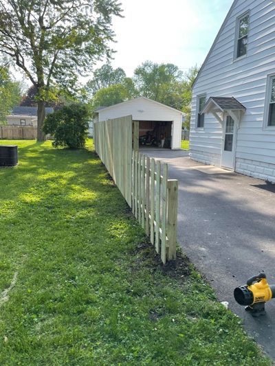 A wooden fence is being built in front of a house.
