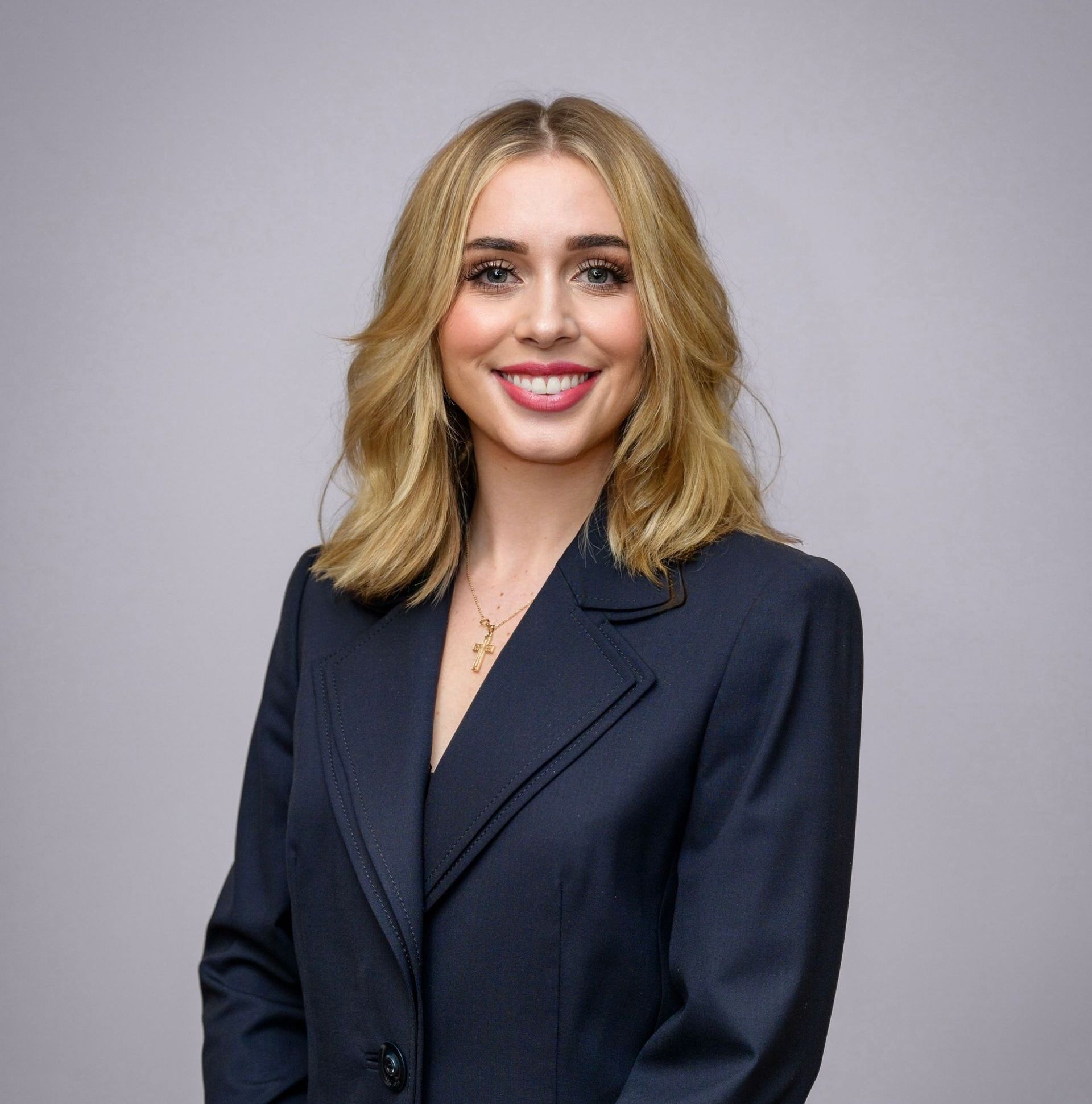 A woman in a suit is smiling for the camera