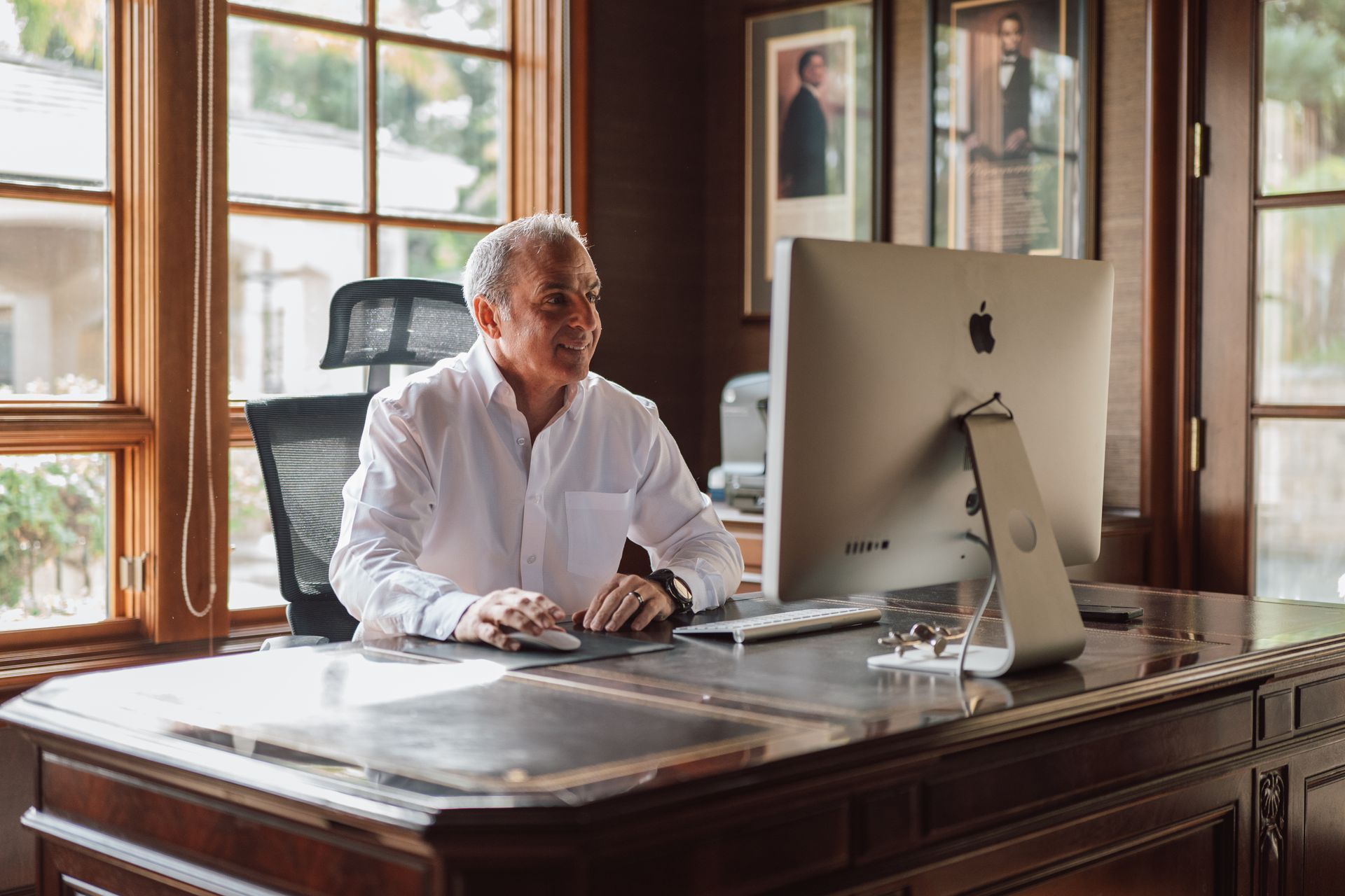 A man is sitting at a desk in front of a computer.