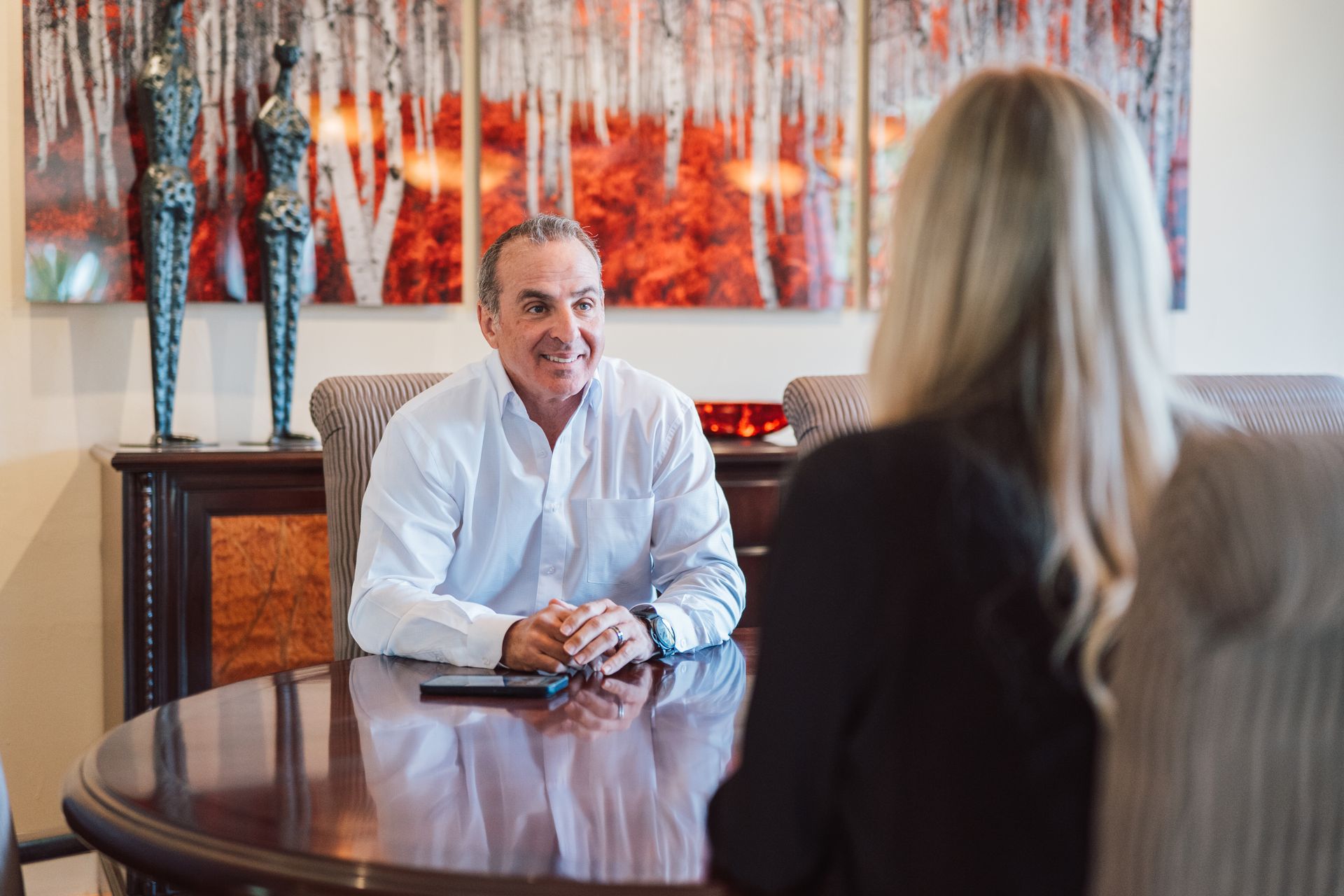 A man and a woman are sitting at a table having a conversation.
