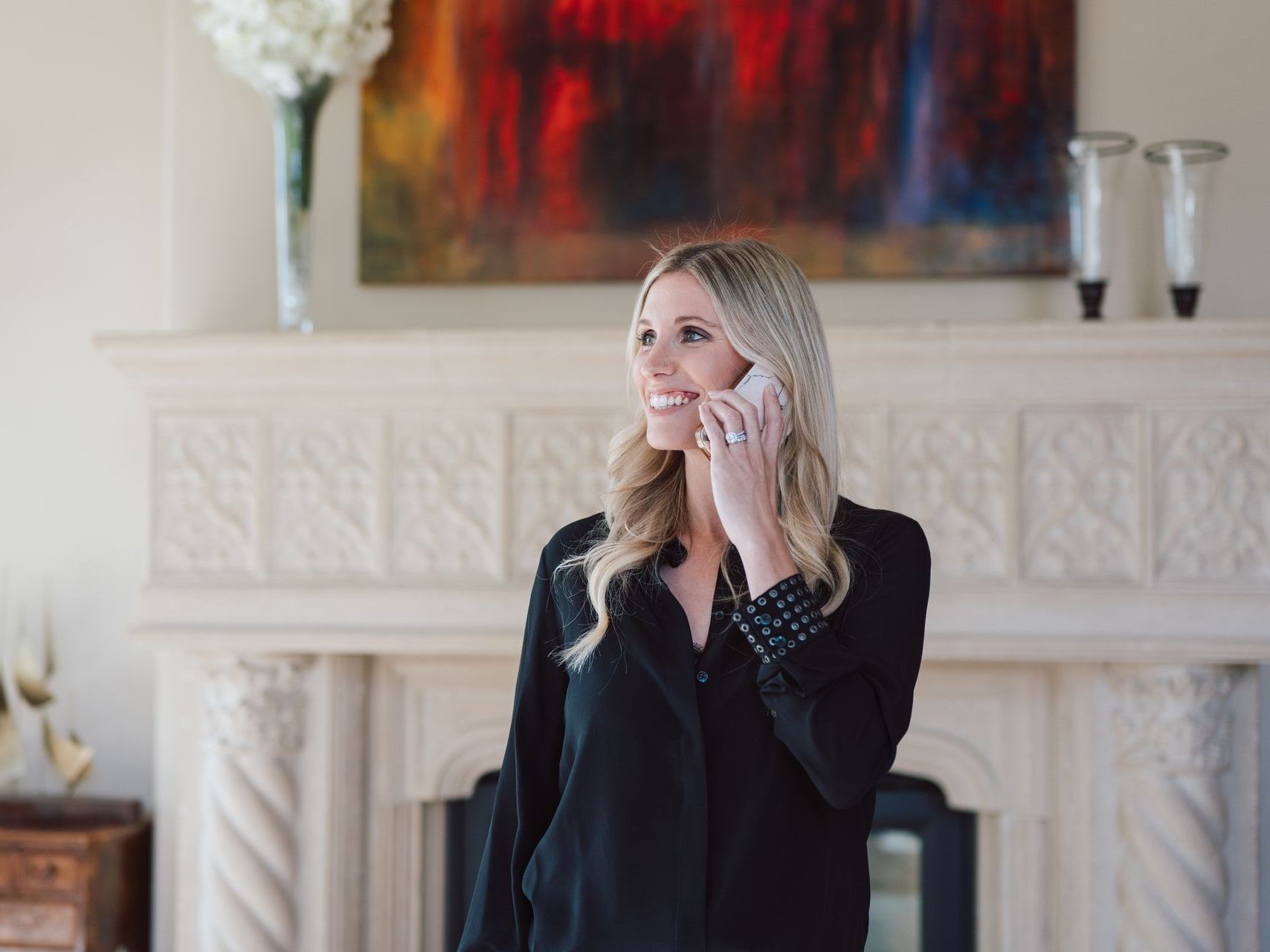A woman is talking on a cell phone in a living room.