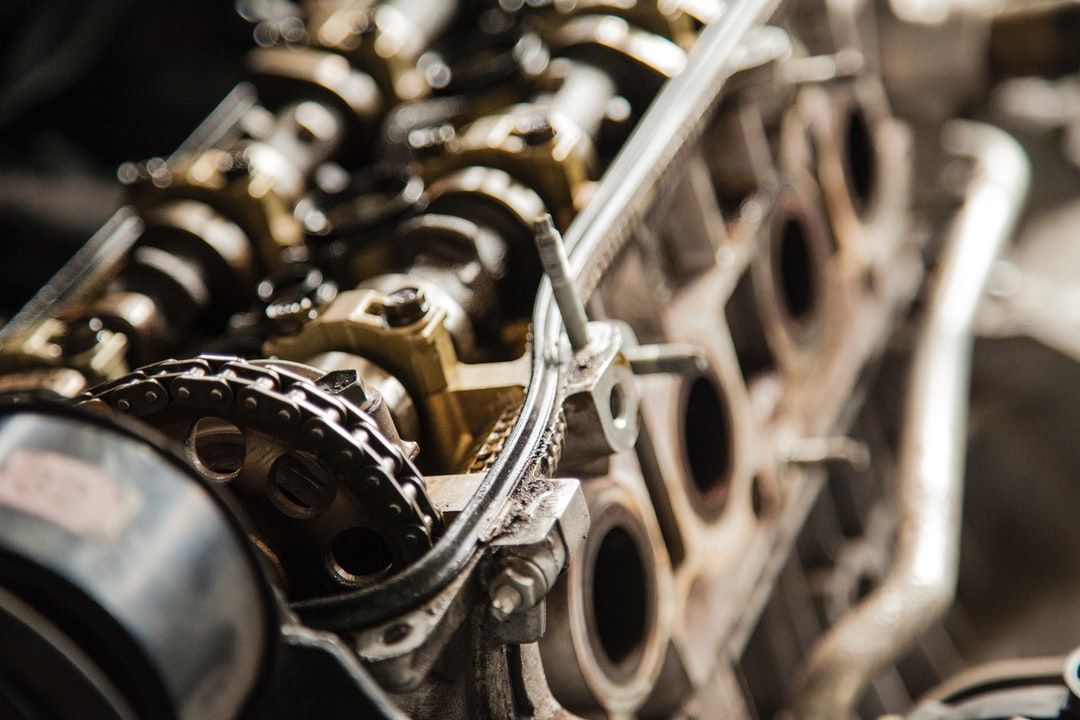Close-up of a car engine’s exposed camshaft and timing chain components.