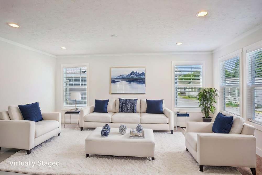 Living room with white furniture, blue accents, and a landscape painting.