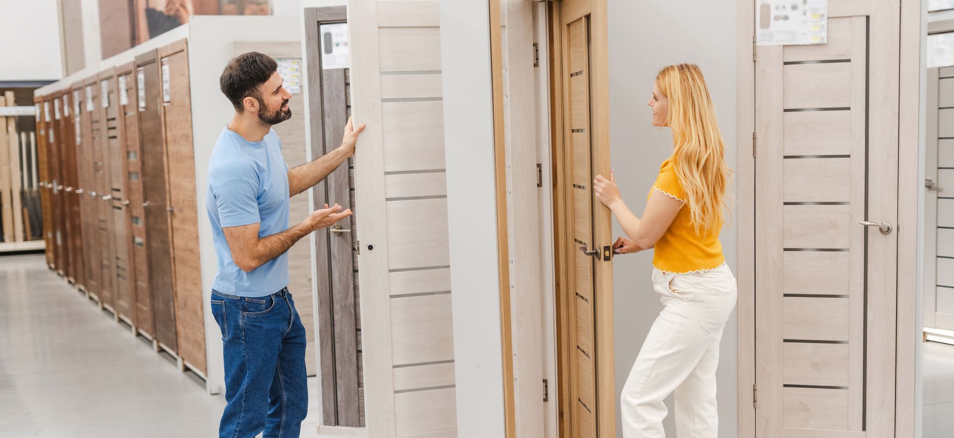 A man and a woman are looking at a door in a store.