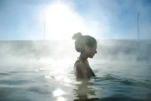 A Woman Is Taking A Bath In A Hot Tub — North West Heating, Cooling and Refrigeration in Taminda, NSW