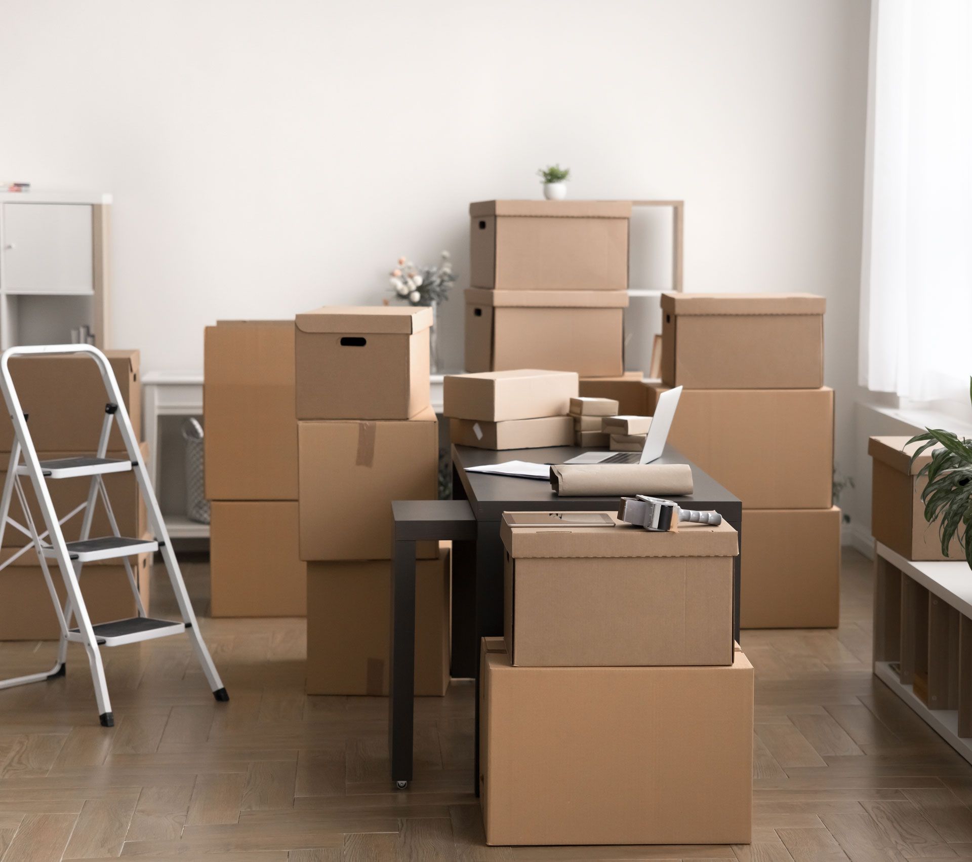 A woman is holding a cardboard box in a storage unit