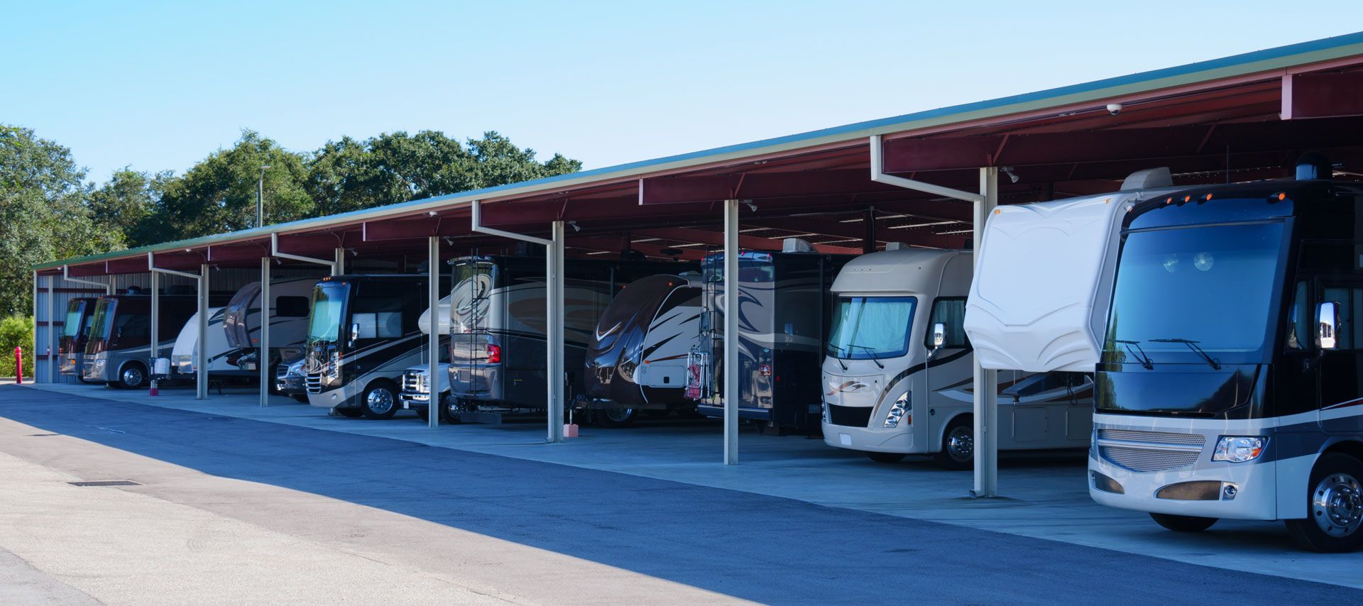 A row of rvs parked under a covered parking lot.
