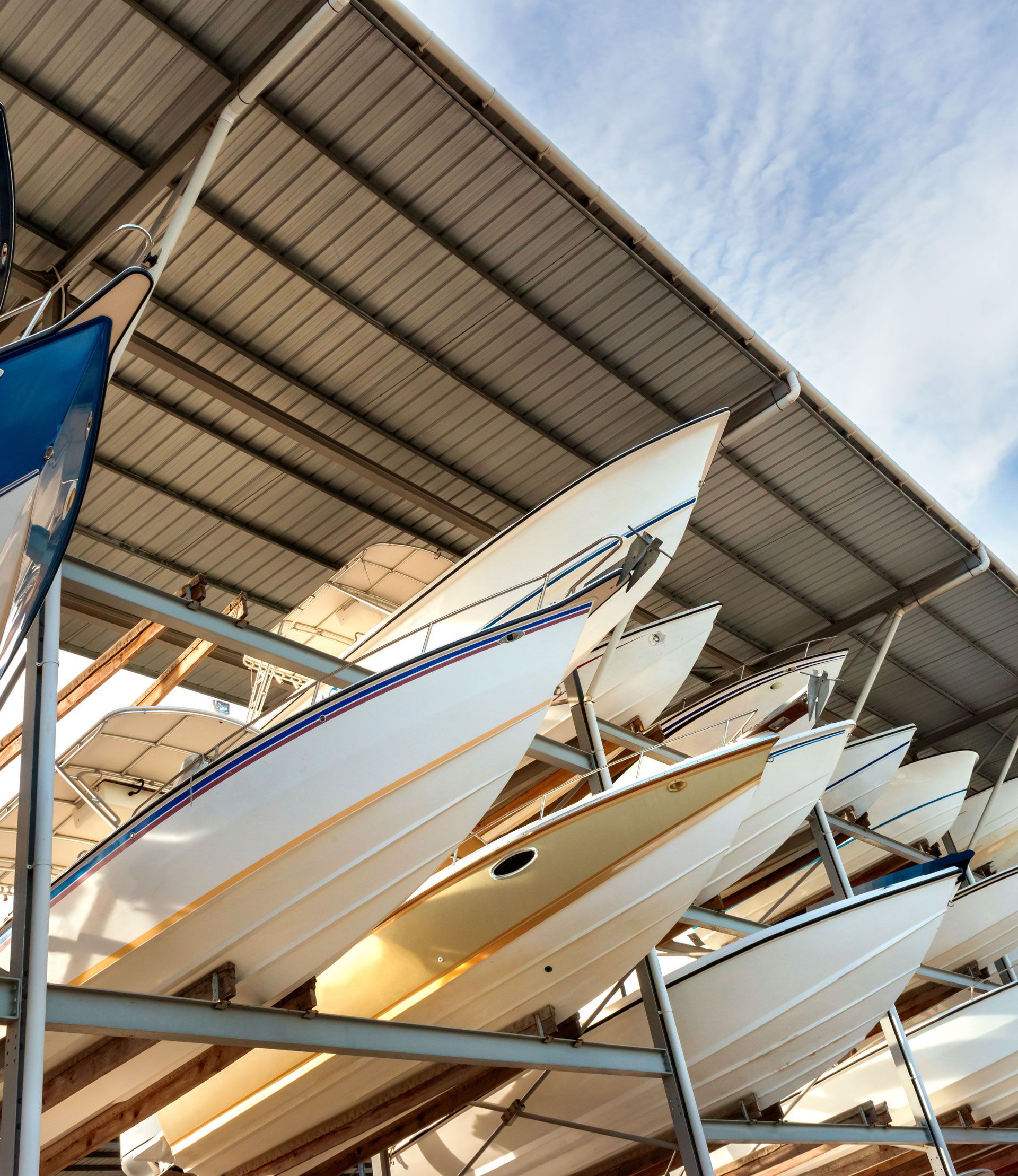 A bunch of boats are lined up under a roof