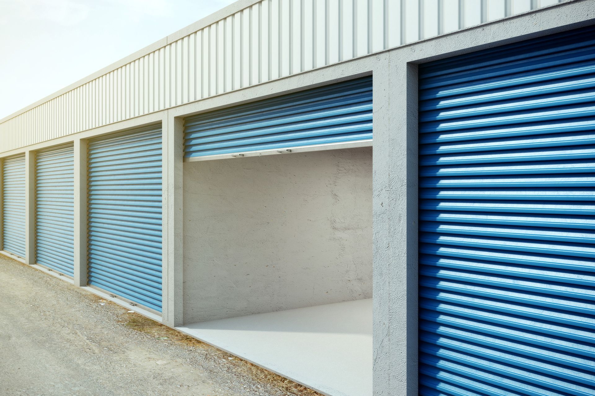 A row of empty storage units with blue roller doors.