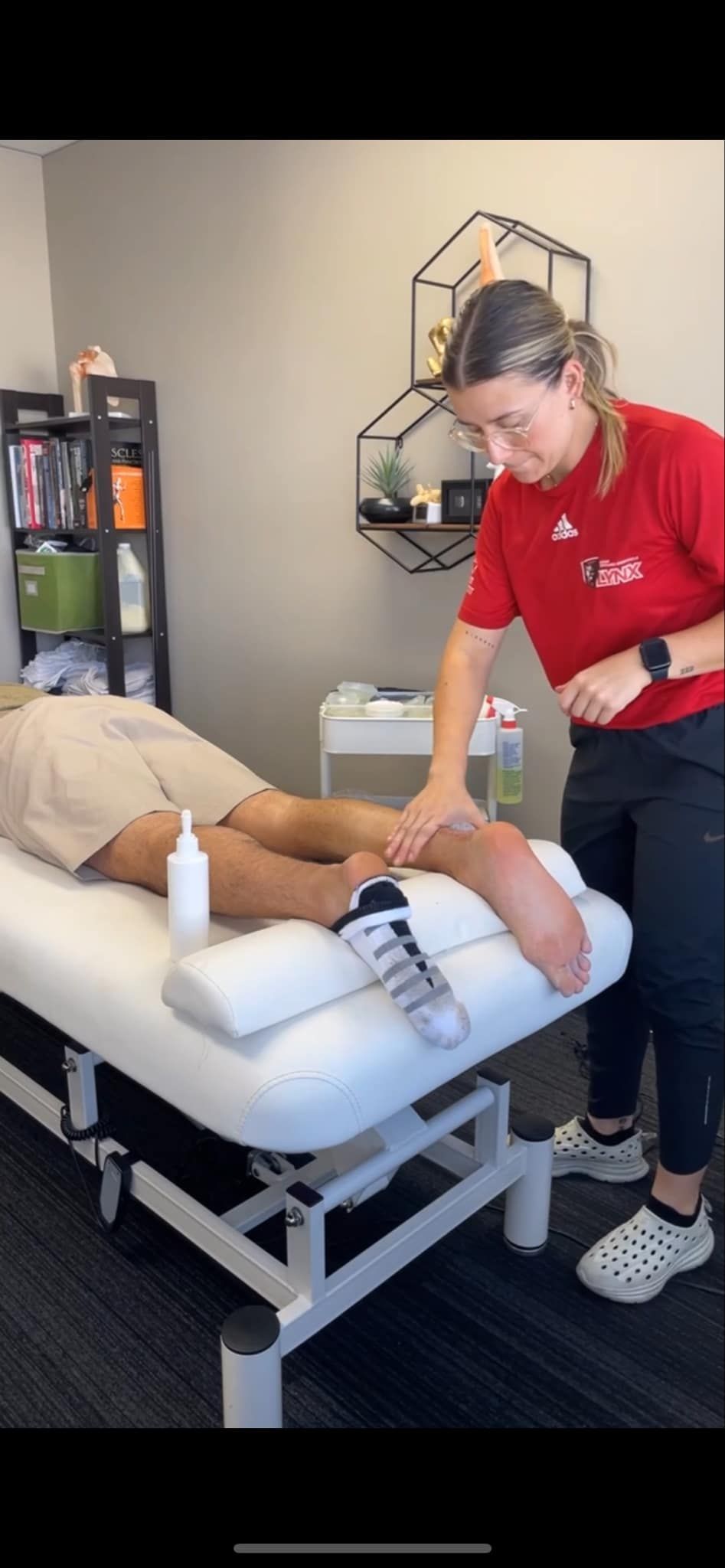 A woman is giving a man a foot massage on a table.