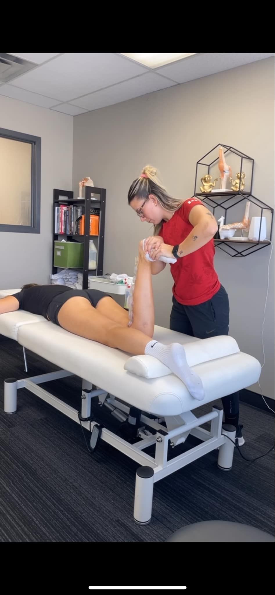 A woman is giving a person a massage on a table.