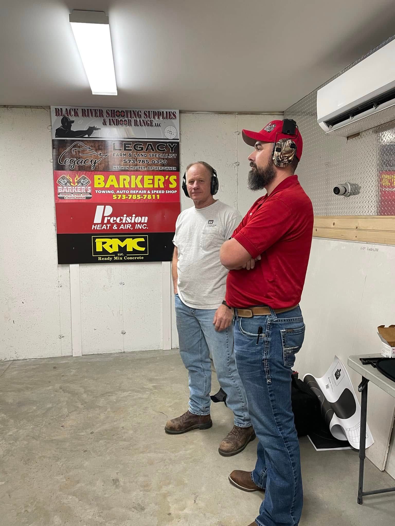 Two men are standing in a room with a poster on the wall.