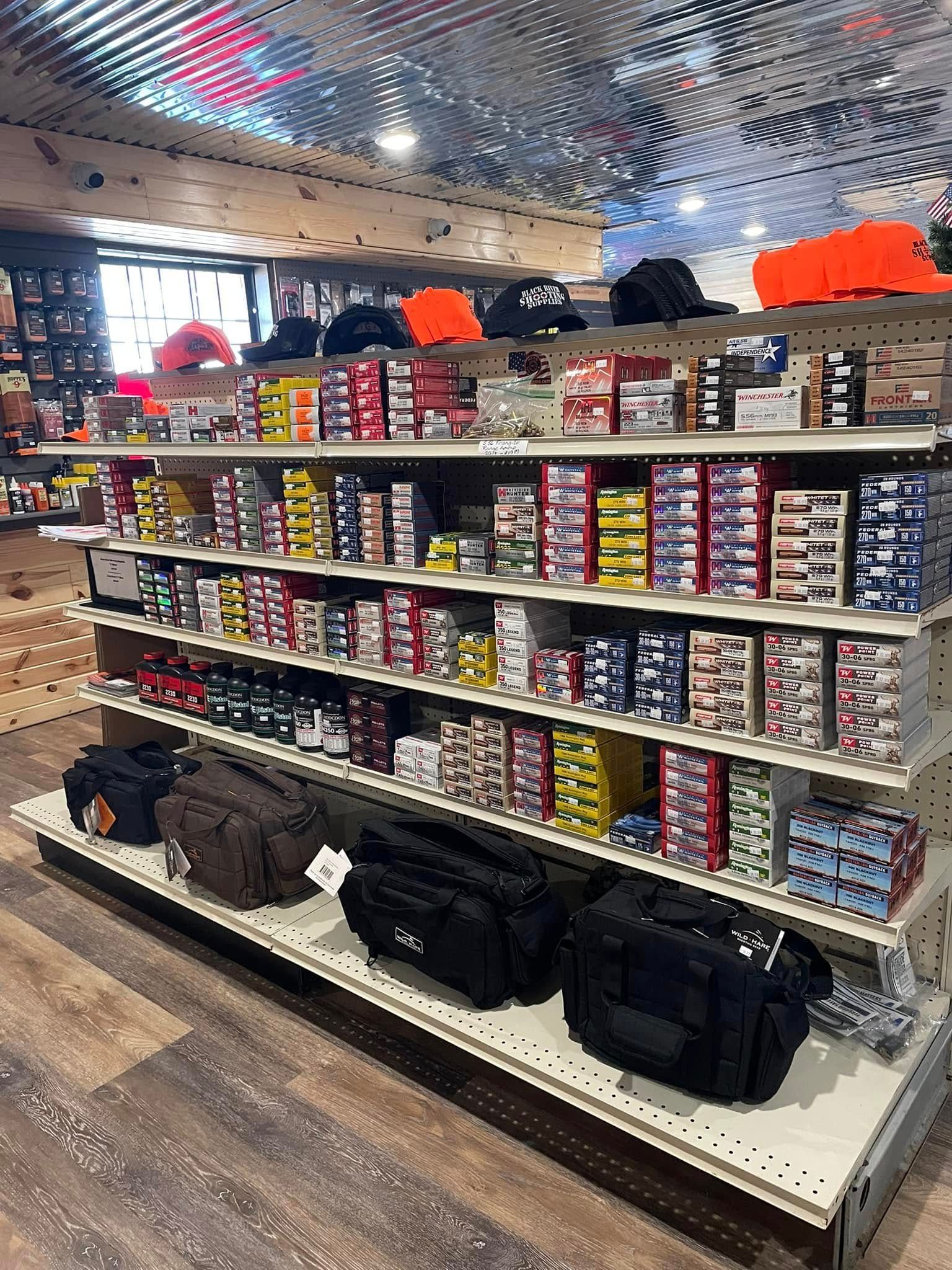 A store shelf filled with lots of ammunition and bags.